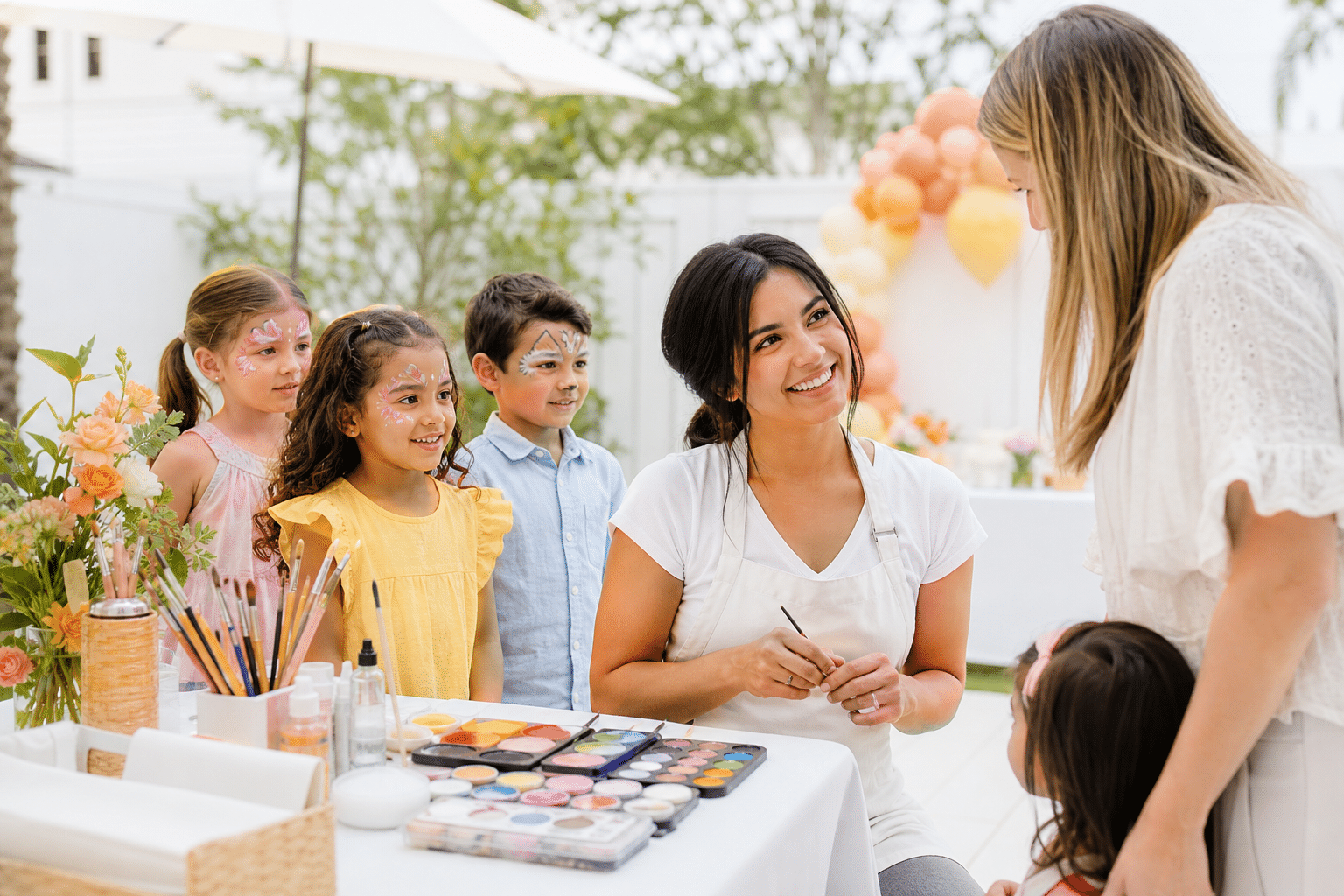 Premium mobile face painting studio setup with artist, parent, and children